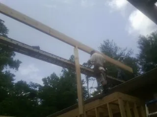 Carpenter setting a ridge beam over a new addition frame — Ice Dam Removal by Roofing Brothers in Lebec
