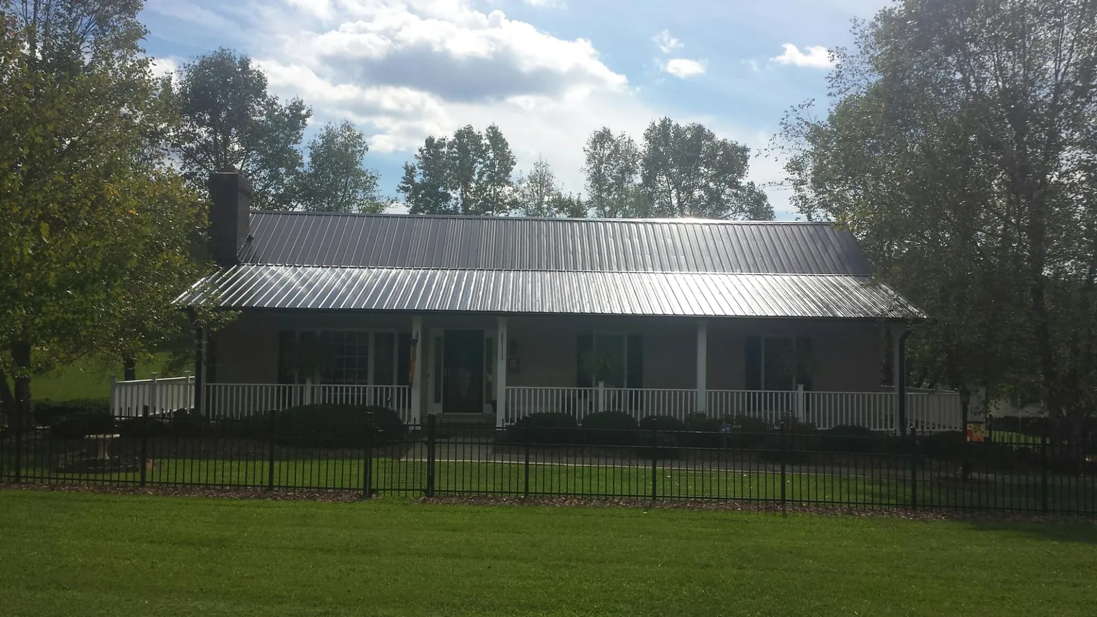 Gray metal roof on a brick ranch with a full width front porch — Gutter Guard Installation work by our crew in Lebec
